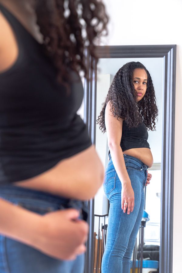 Una donna tiene in mano un paio di jeans